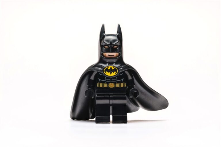 Figura LEGO de Batman con traje negro y logo amarillo, portada de artículo sobre Batman en LEGO y su nuevo videojuego 2026