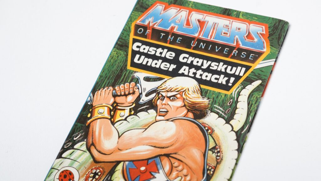Portada retro de Masters del Universo con He Man defendiendo Castle Grayskull, arte clásico que inspira el nuevo videojuego con batallas épicas.