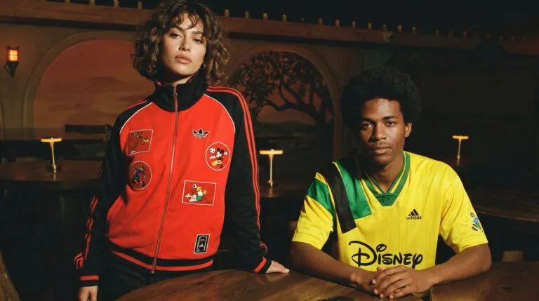 Dos modelos lucen una colección de moda inspirada en el futbol retro con prendas de estilo urbano y estética noventera.