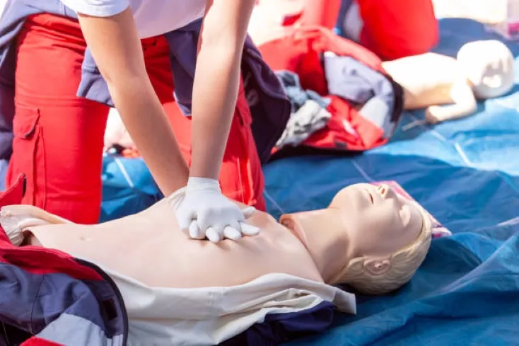 Persona practicando reanimación cardiopulmonar con el simulador OpenCPR